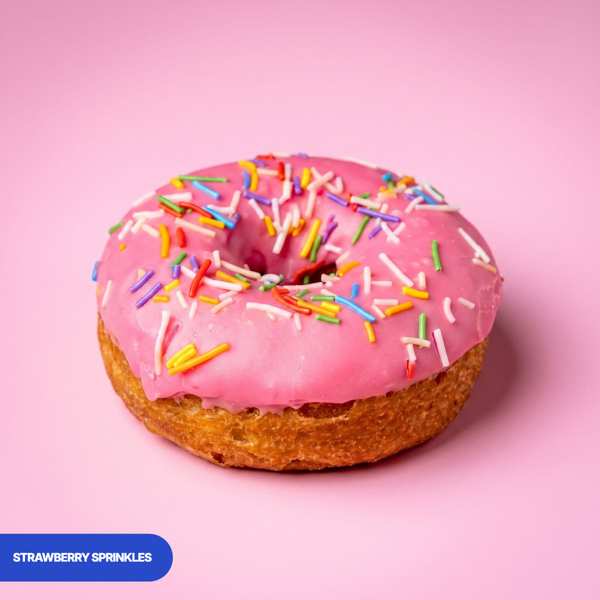 Gluten free oat free vegan fried strawberry ring doughnut, pink icing covered in rainbow sprinkles